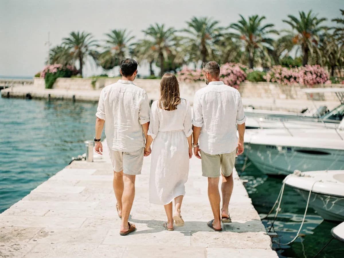 A couple and a local host walking a stone marina quay